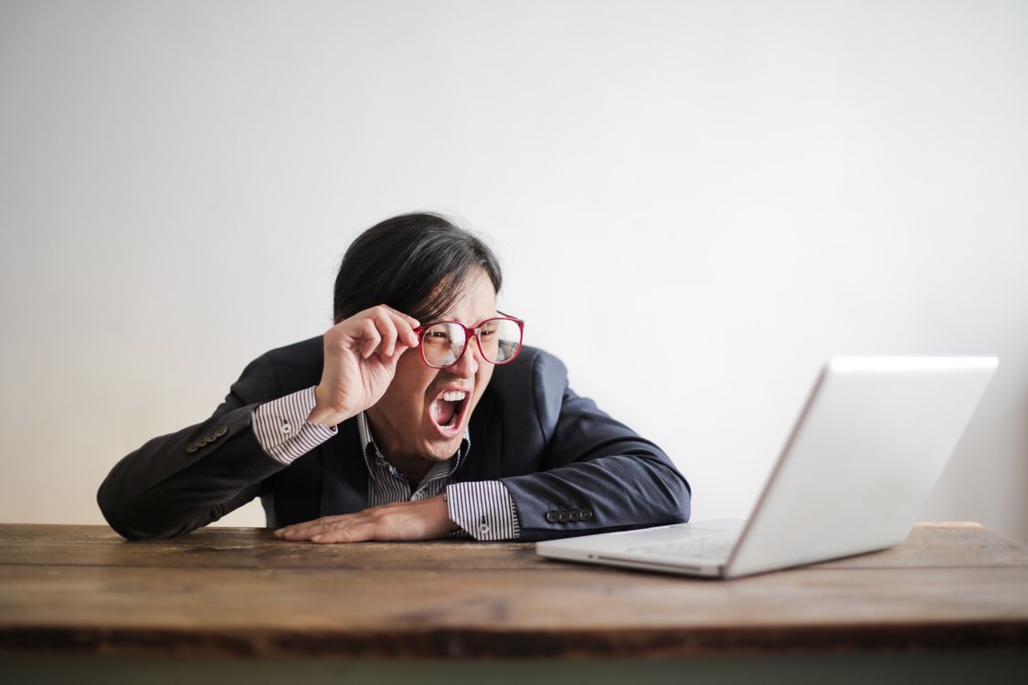 Yelling formal man watching news on laptop