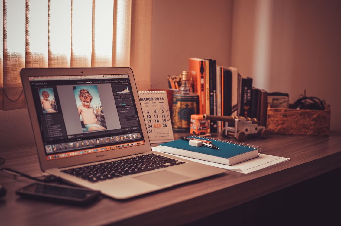 Turned on Screen Silver Macbook Air on Wooden Desk